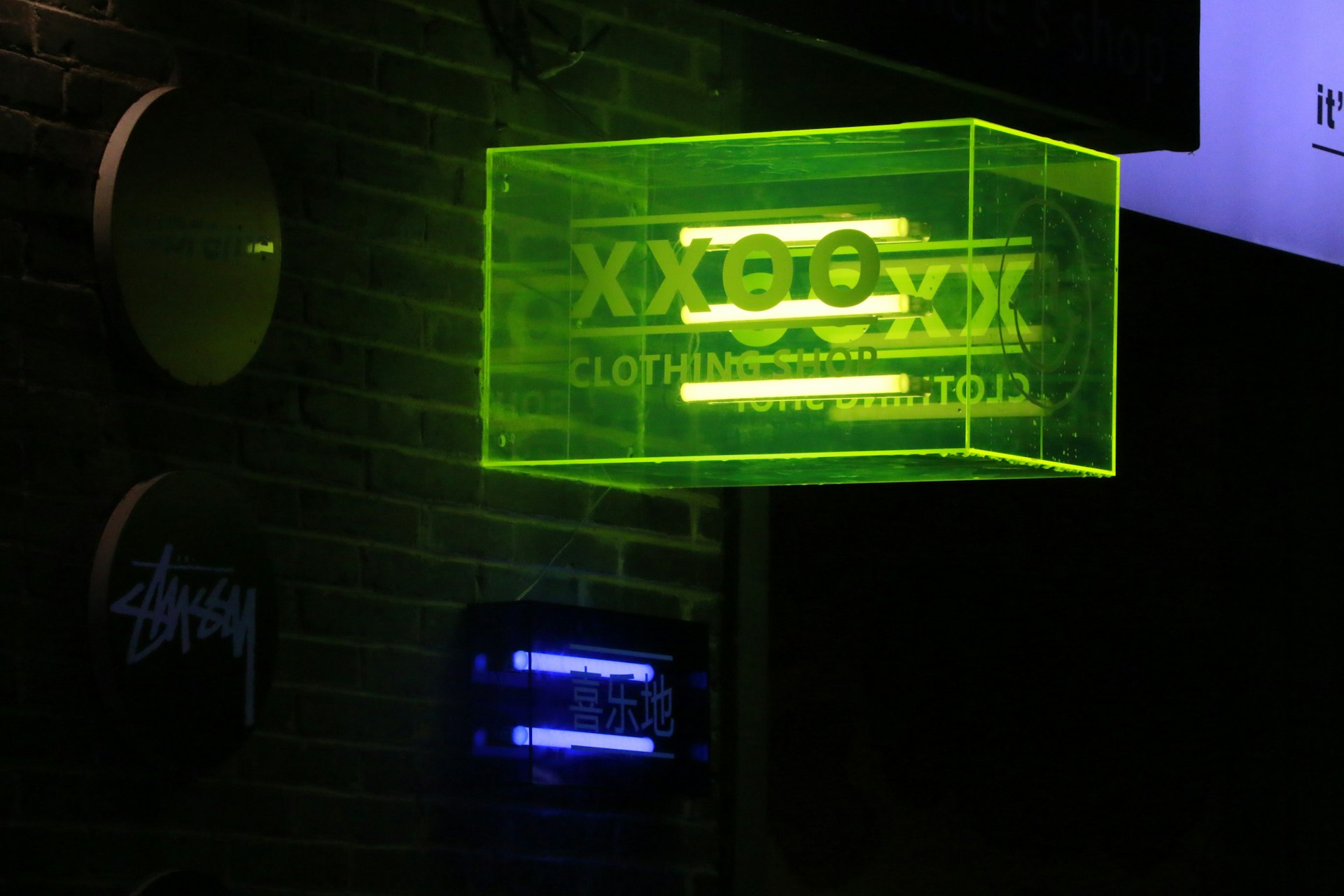 a neon sign hanging from the side of a brick building